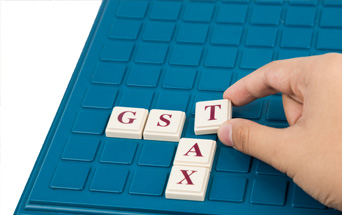 GST TAX letters on a blue board game