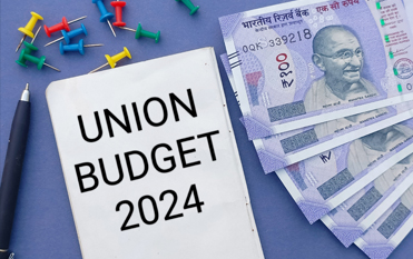 Union Budget 2024 note, pen, and Indian currency notes on a desk symbolizing financial planning